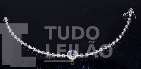 Pulseira Riviera de ouro branco 18k, com 56 diamantes redondos totalizando aproximadamente 0,65 ct e tanzanita formato de coração de aproxim...