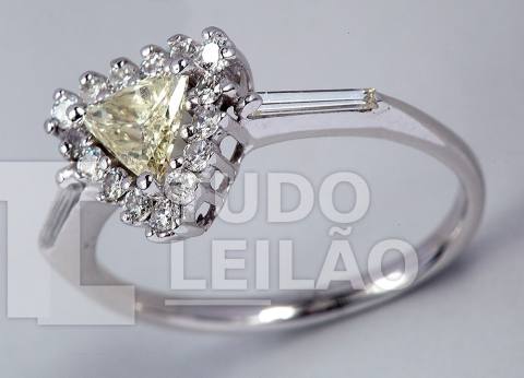 Lindo anel em ouro branco 18k, com diamante central Fancy Yellow, de lapidação trillion, com aproximadamente 4,80 mm x 4,80 mm, adornado por...