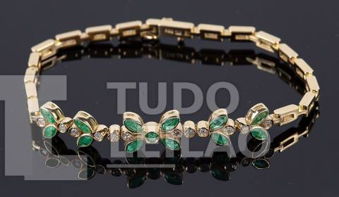 Pulseira em ouro amarelo 18k, com 13 esmeraldas de lapidação navete e redonda ao centro. 12 diamantes redondos