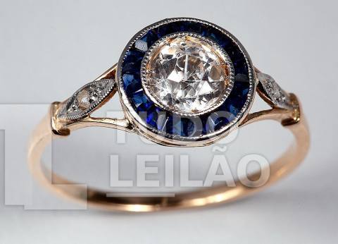 Anel em ouro amarelo 18k, com 15 safiras e 1 diamante central de lapidação Brasil de aproximadamente 0,55 ct. Aro: 18